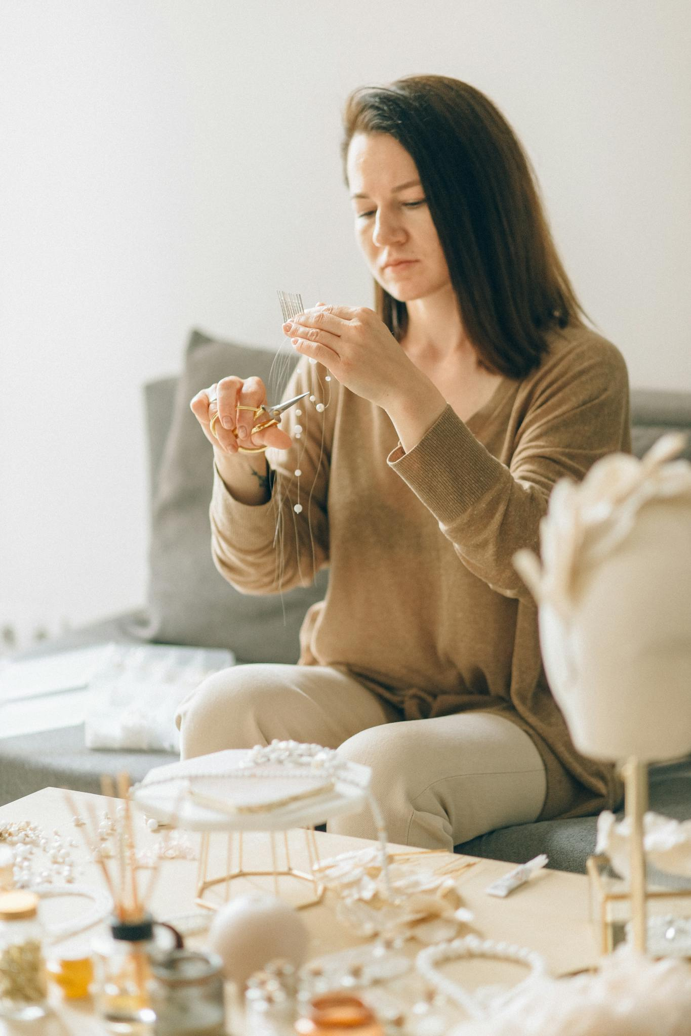 Photo by Nataliya Vaitkevich Adult woman focused on crafting handmade jewelry with beads indoors.