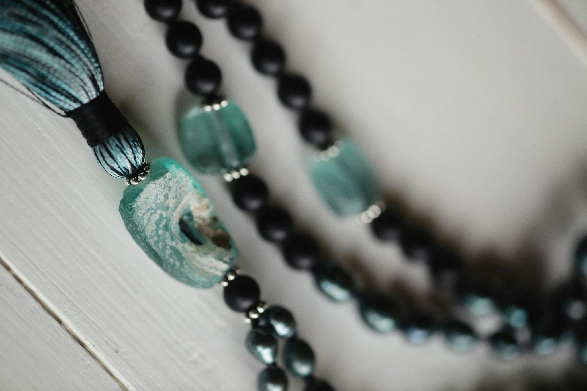 Photo by Alexey Demidov Close-up of a beaded jewelry piece with teal accents, emphasizing spirituality and craftsmanship.