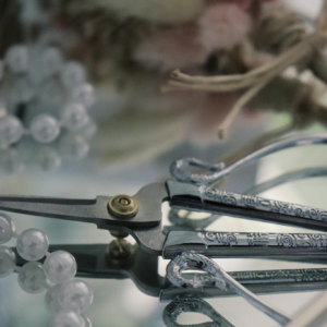 Close-up of elegant pliers with beads and floral accents, offering precision and charm.