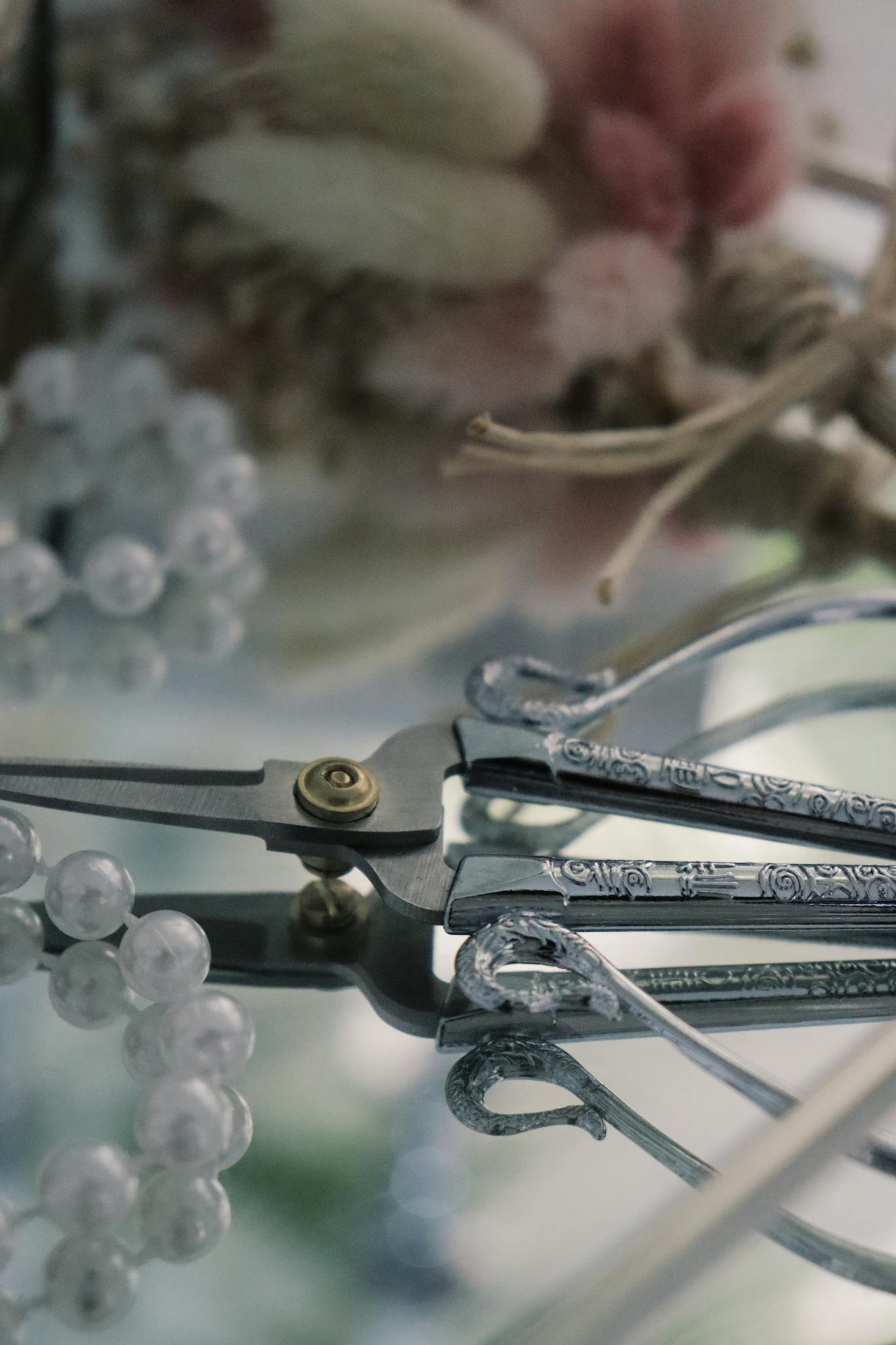 Photo by kübra zehra Close-up of elegant pliers with beads and floral accents, offering precision and charm.